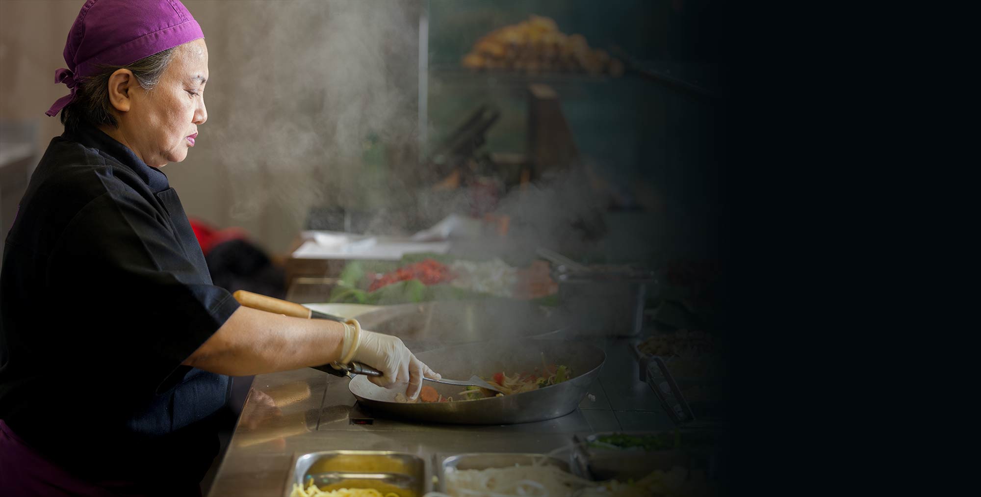 Chefköchin Somkhit beim Kochen mit einer Gemüsepfanne