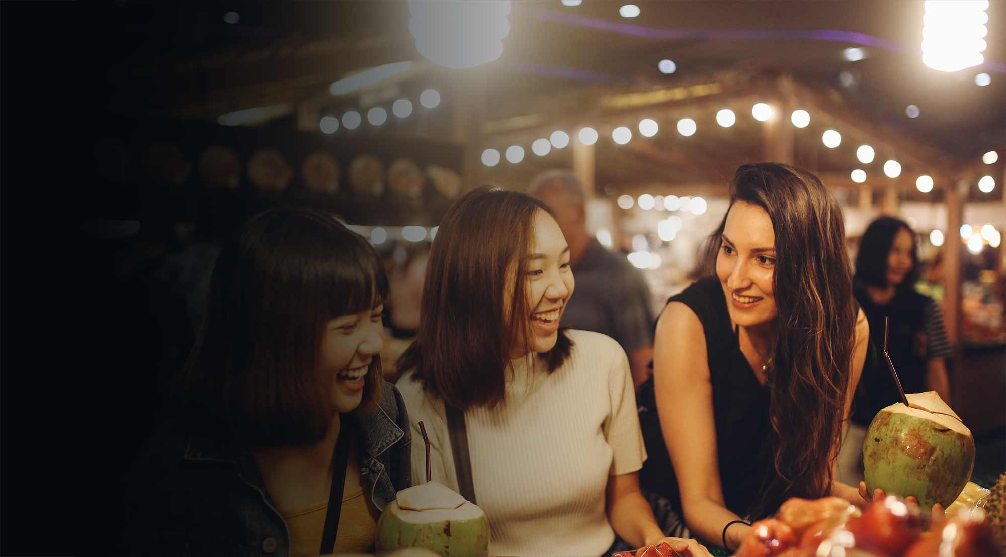 Drei Frauen an der Cocktailbar in einem asiatischem Restaurant mit Abendstimmung