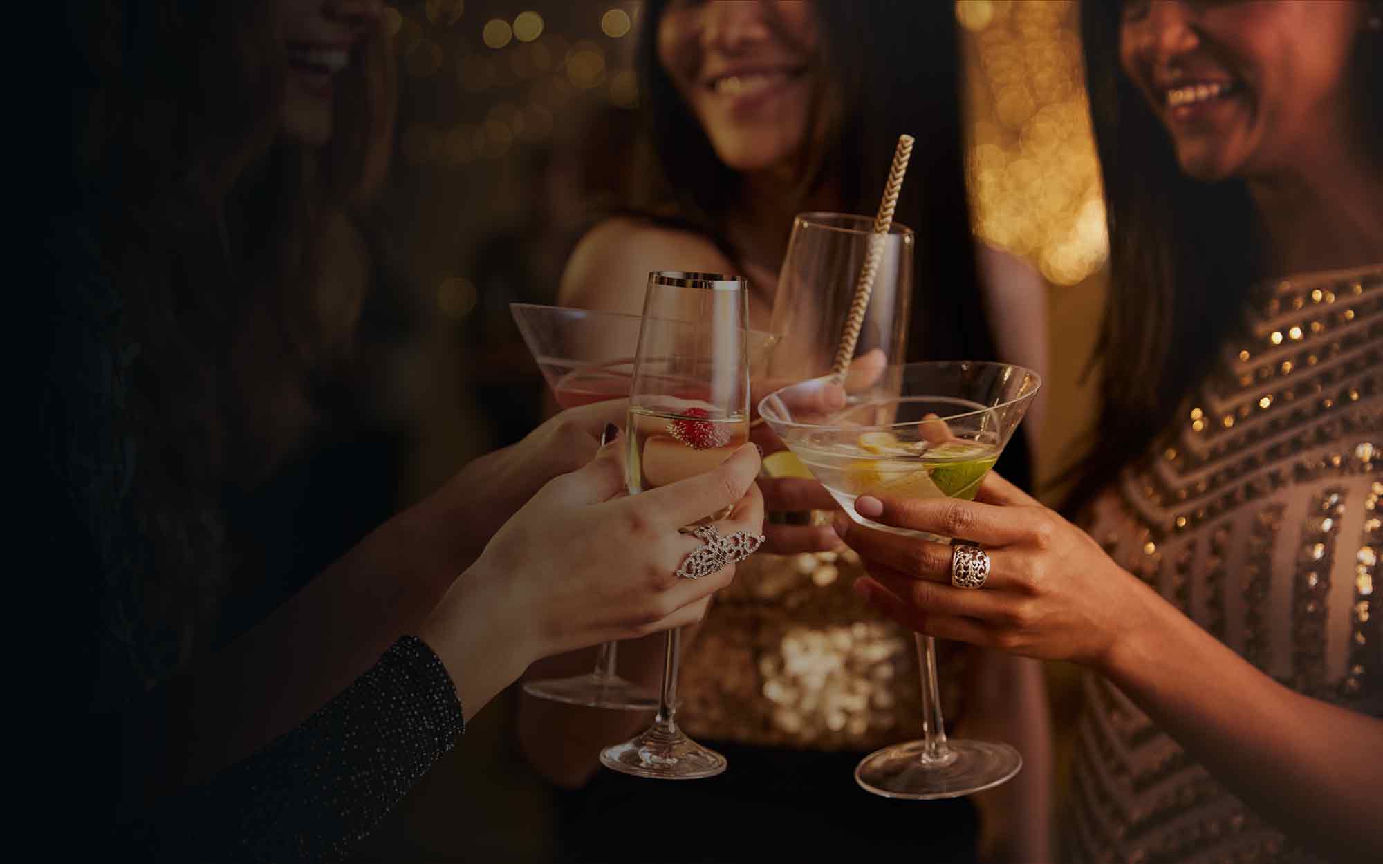 Frauen in Abendgarderobe stoßen mit Cocktails an